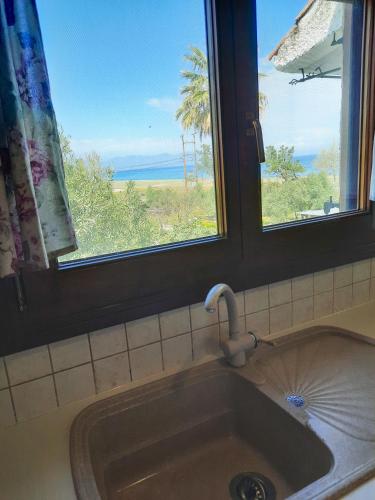 lavabo con ventana y vistas al océano en Aktaia Villa, en Ierissos