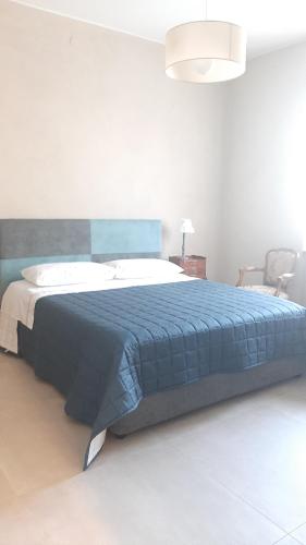 una camera da letto con un grande letto con una coperta blu di Locazione turistica Corner 20 a Piacenza