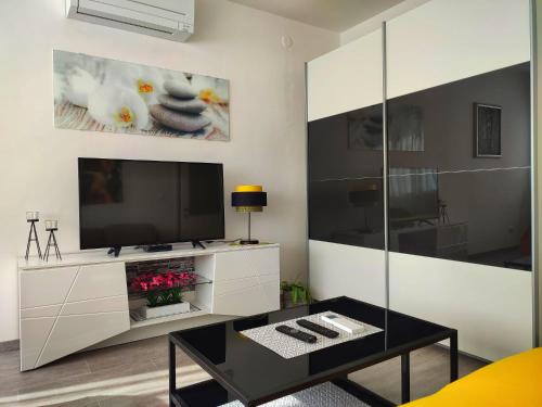 ein Wohnzimmer mit einem TV und einem Couchtisch in der Unterkunft Apartment Siesta in Split