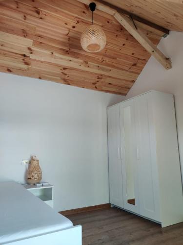 a room with white cabinets and a wooden ceiling at Wild Carp in Dunavăţu de Jos