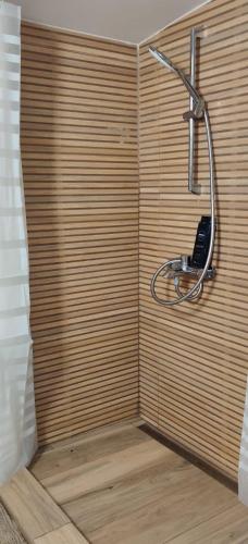 a shower with a phone on a wooden wall at Wild Carp in Dunavăţu de Jos