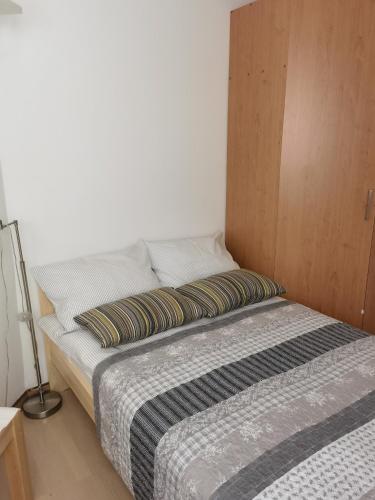 a bed with two pillows on it in a room at BALCON Apartments in Bled