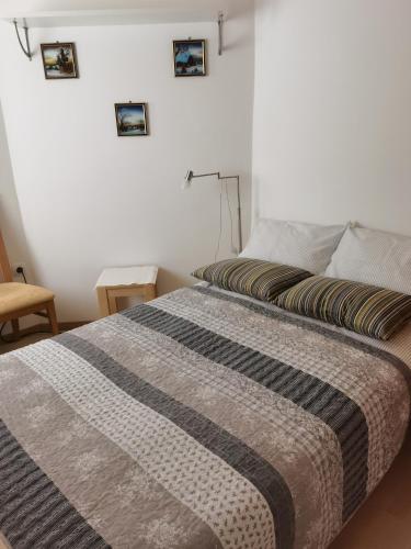 a bedroom with a bed with a striped blanket on it at BALCON Apartments in Bled