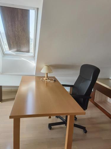 an office with a desk and a chair with a lamp at BALCON Apartments in Bled