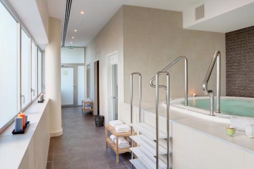 Best Western Plus Hôtel Isidore في سانت جاكس دي لا لاند: حمام مع حوض ومغسلة