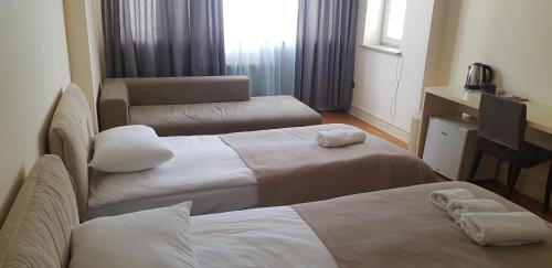 a hotel room with two beds and a chair at Baku Sea View Hotel in Baku