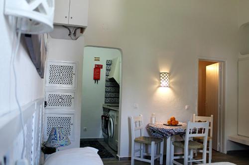 een kleine eetkamer met een tafel en stoelen bij Óasis - Pedras D' El Rei T0 in Santa Luzia