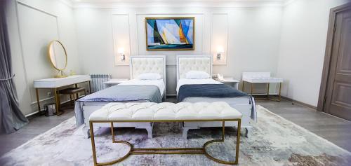 a bedroom with two beds and a mirror at Grand Holiday Hall in Pavlodar