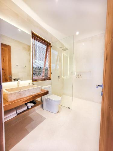 a bathroom with a sink toilet and a shower at Neano Escape in Candidasa