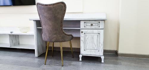 a desk with a chair next to a white desk at Grand Holiday Hall in Pavlodar