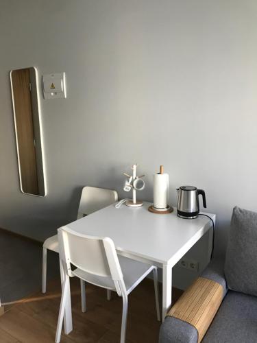 a white dining room table and a chair and a couch at Pepleri Studio 20 in Tartu