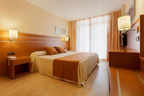 a hotel room with two beds and two lamps at Hotel Beverly Park & Spa in Blanes