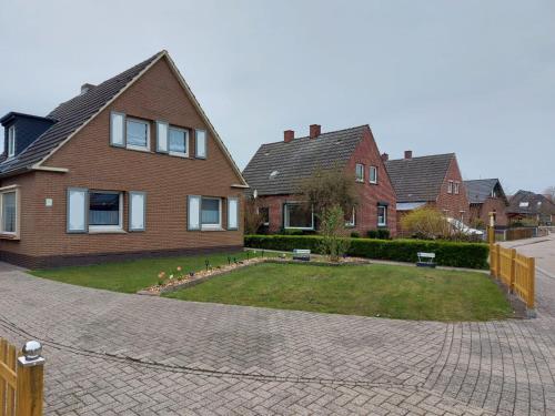 a house with a brick driveway in front of a yard at Ferienwohnung/Norden/4Personen in Norden
