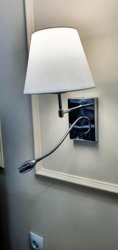 a light on a wall with a lamp on it at Grand Holiday Hall in Pavlodar