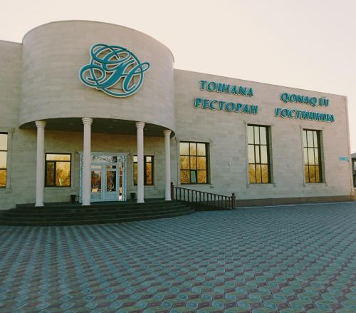 a building with a sign on the front of it at Grand Holiday Hall in Pavlodar