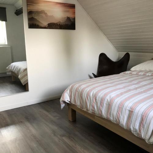a bedroom with a bed and a black chair at Ferienwohnungen Mechernich-Gehn in Mechernich