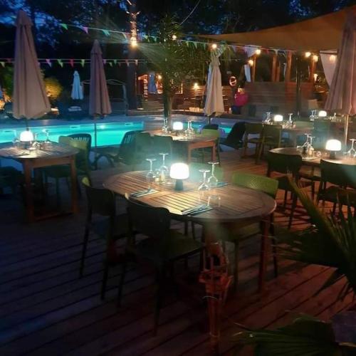 a group of tables and chairs on a deck at night at Camping U STABIACCIU in Porto-Vecchio