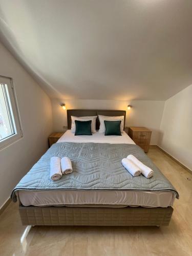 una camera da letto con un grande letto con due asciugamani di Venice Apartments a Tivat
