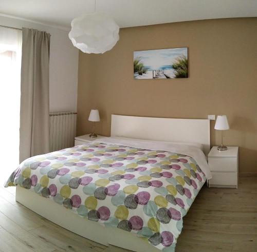 1 dormitorio con 1 cama grande con colcha de flores en Apartments Ostanek 2, en Portorož