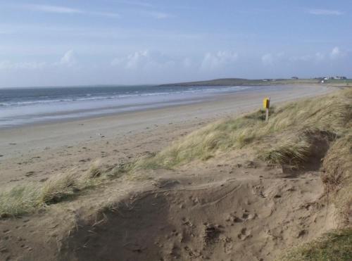 a sandy beach with the ocean in the background at Seascape on the edge of town: 4 beds all ensuite. in Belmullet