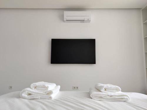 un letto con due asciugamani e una televisione di Barrocas Villas Azores a São Roque
