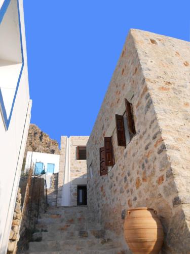 a stone building with a vase on the side of it at villa Elpiniki Tilos in Megálon Choríon