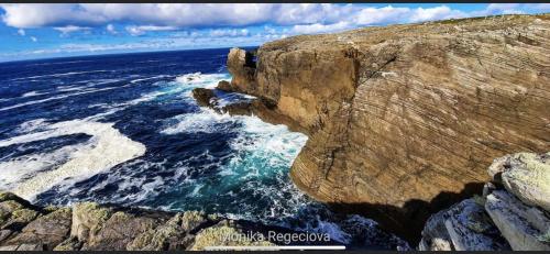 an aerial view of a large rock in the ocean at Seascape on the edge of town: 4 beds all ensuite. in Belmullet