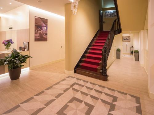 a hallway with a staircase with red carpet at Hotel Roma in Sarria