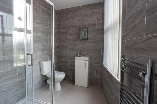 a bathroom with a toilet and a glass shower at TCO Luxury House in Liverpool