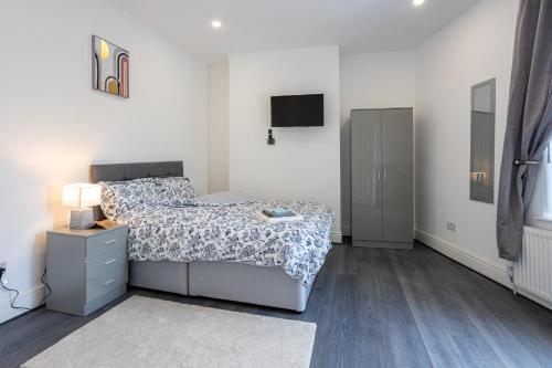 a bedroom with a bed and a tv on the wall at TCO Luxury House in Liverpool