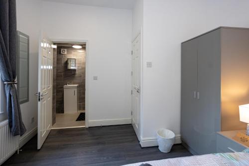 a bedroom with a door leading to a bathroom at TCO Luxury House in Liverpool