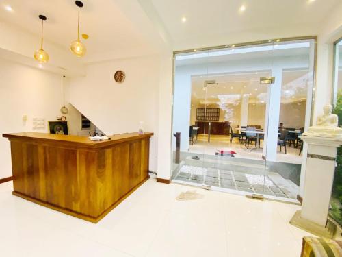 a lobby with a wooden podium and a dining room at Bayfront in Weligama