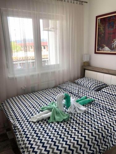 a bedroom with a black and white bed with a window at Tri palme in Banja Koviljača