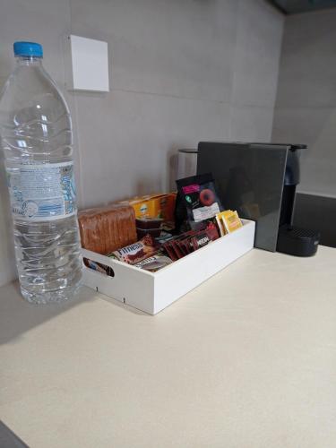 a bottle of water sitting next to a box on a table at Aeolia apartments in Ermoupoli