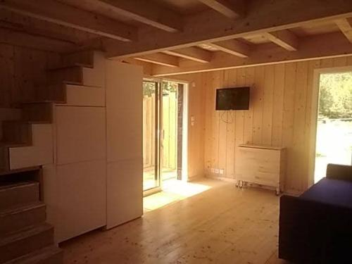 an empty room with a staircase and a room with a television at Studio dans les pins Lacanau in Lacanau