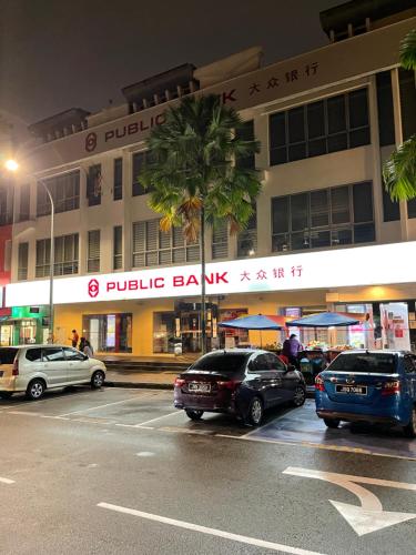 a parking lot with cars parked in front of a building at ZZZ SLEEP MODE CAPSULE in Skudai