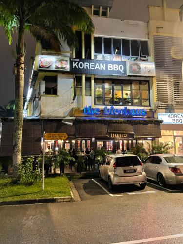 a korean bbq restaurant with cars parked in a parking lot at ZZZ SLEEP MODE CAPSULE in Skudai