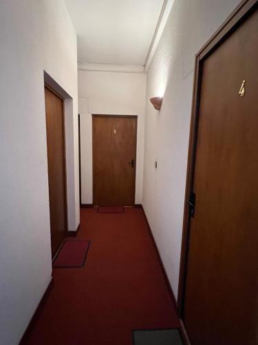 un couloir avec deux portes et un tapis rouge dans l'établissement Reims confort, à Reims