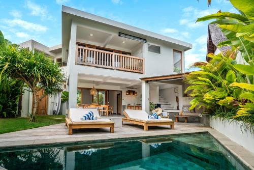 a villa with a swimming pool and a house at Yume Villas in Uluwatu