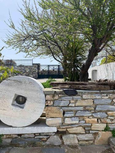 a stone wall with a tree in the background at Fabrica apartments in Apeiranthos