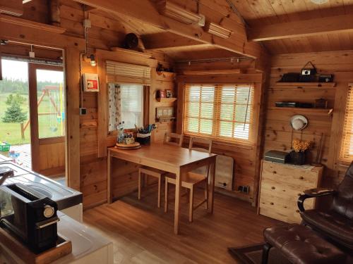 comedor con mesa en una cabaña de madera en Cosy Cabin by Lake & Woods with Views, en Selfoss