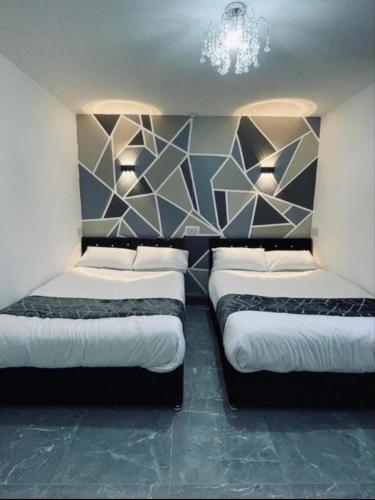 - 2 lits dans une pièce avec un mur dans l'établissement Entire 5 Star Luxury Whalley House Wifi TV Luxury, à Burnley