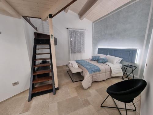 1 dormitorio con cama, escalera y silla en CENTO FIORI, en Castel San Giovanni