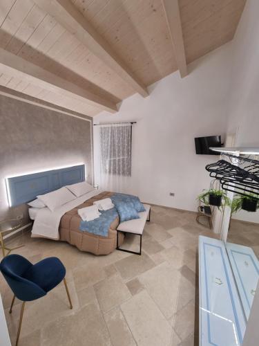 1 dormitorio con 1 cama y 1 silla azul en CENTO FIORI, en Castel San Giovanni