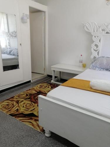 1 dormitorio con cama y alfombra de rosa en Golden Nest, en Mombasa