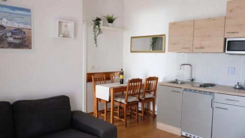 a kitchen and a living room with a table and a couch at Apartments Dubravka in Medulin
