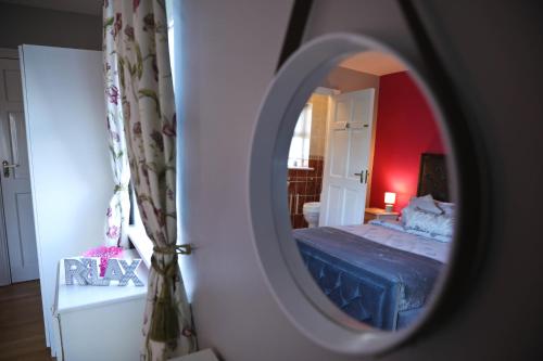 a bedroom with a blue bed and a mirror at Seascape on the edge of town: 4 beds all ensuite. in Belmullet
