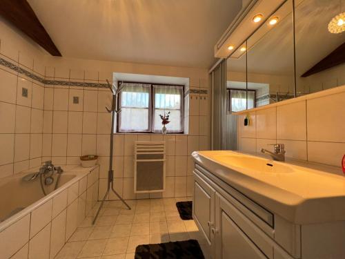 a bathroom with a tub and a sink and a bath tubermottermott at Proche le Mans, Parigné l'Evêque,maison forestière, accueil chevaux possible 11 pers in Parigné-lʼÉvêque