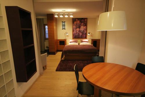 Apartment Na Krki في Kostanjevica na Krki: غرفة نوم بسرير وطاولة في غرفة