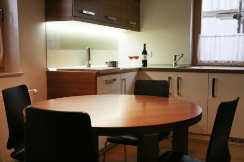 a kitchen with a table and chairs and a bottle of wine at Apartment Na Krki in Kostanjevica na Krki